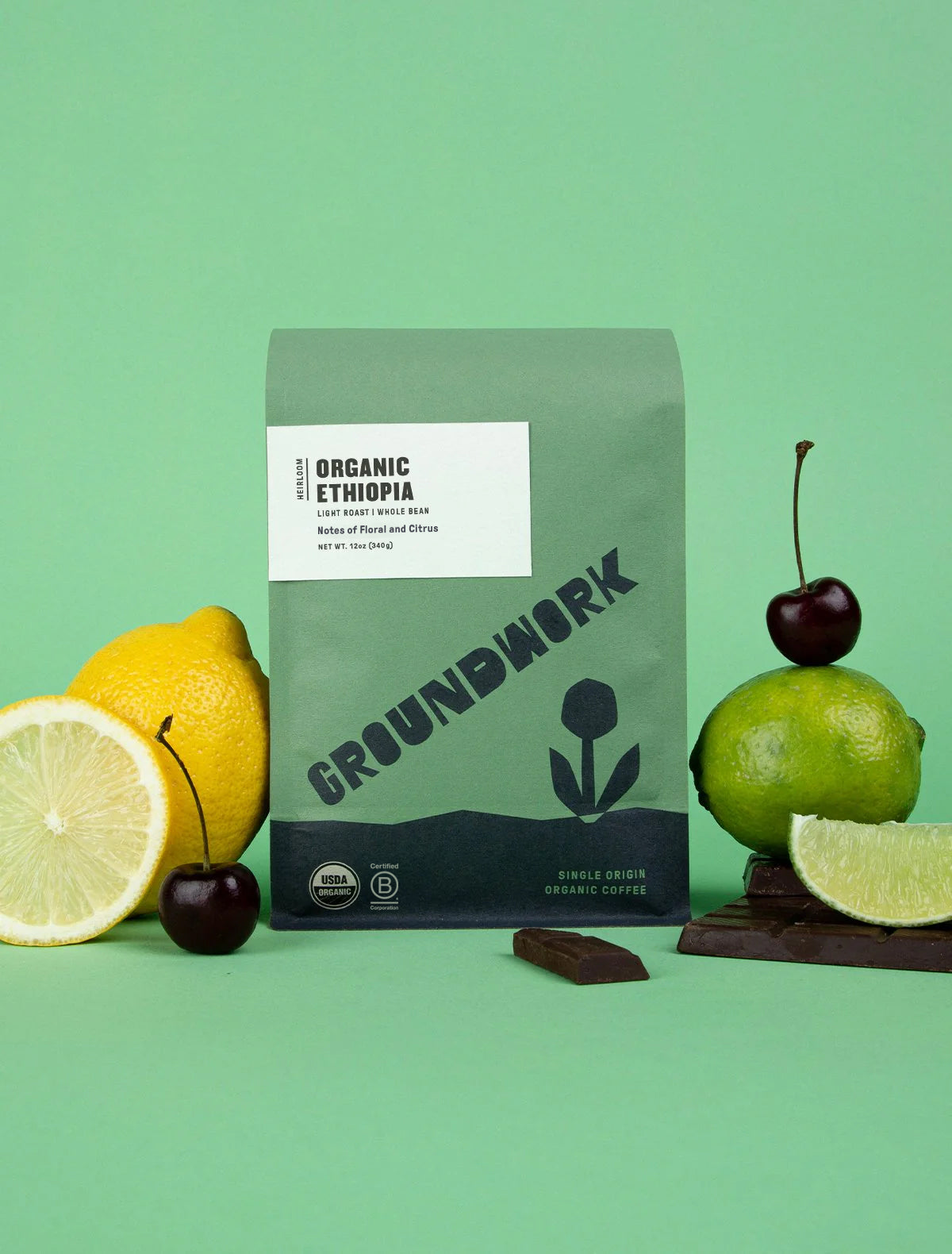 A bag of Groundwork Coffee's Ethiopia: Heirloom Blend is shown with lemon, lime, cherries, and chocolate on a green background.