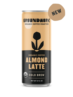 A can of Groundwork Coffee Organic Cold Brew Latte, with a black and beige design, a flower graphic, and a "NEW" label at the top right.