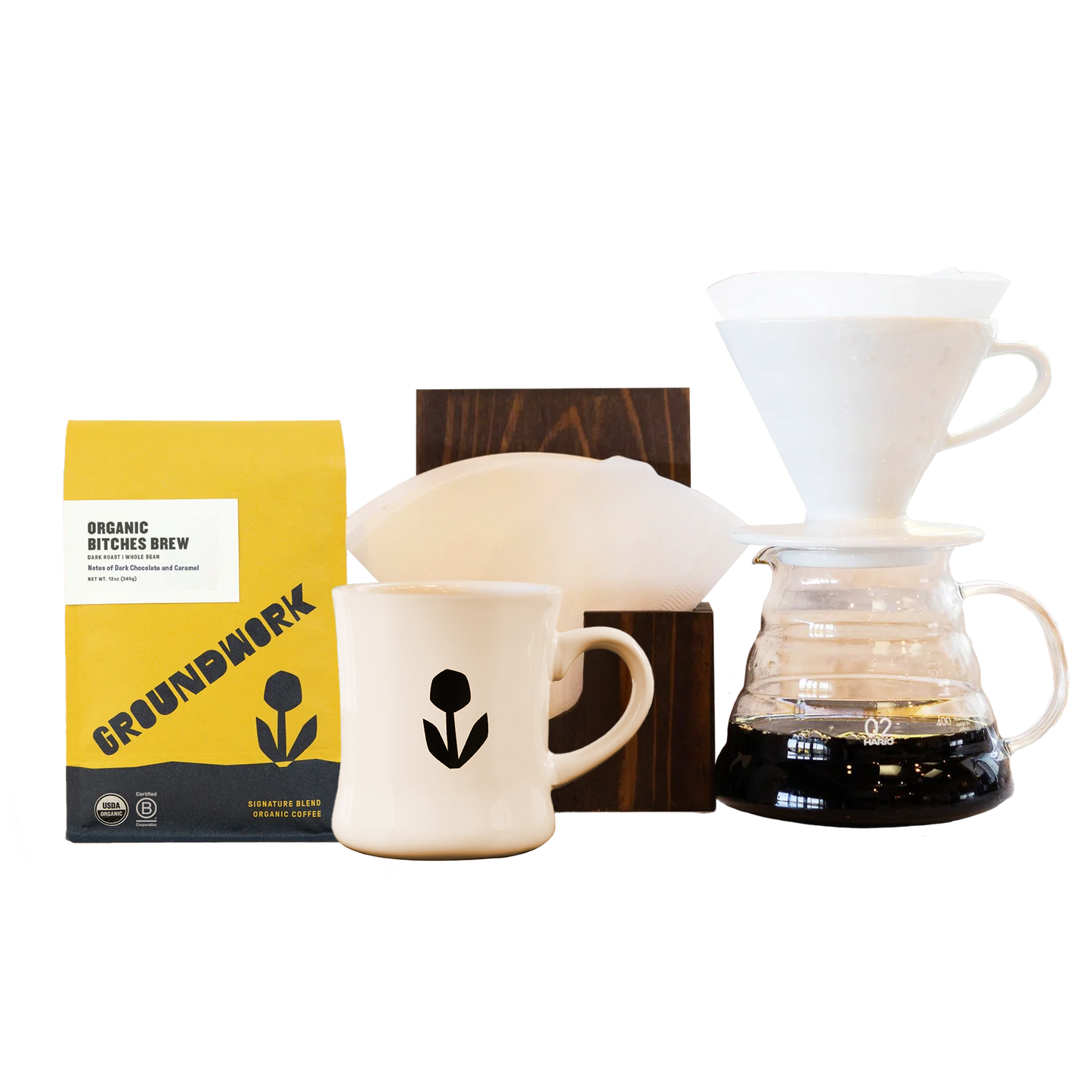 The Hario V60 Pro Bundle from Groundwork Coffee includes a bag of coffee, a white ceramic mug, and filters—ideal for the perfect pour-over experience.