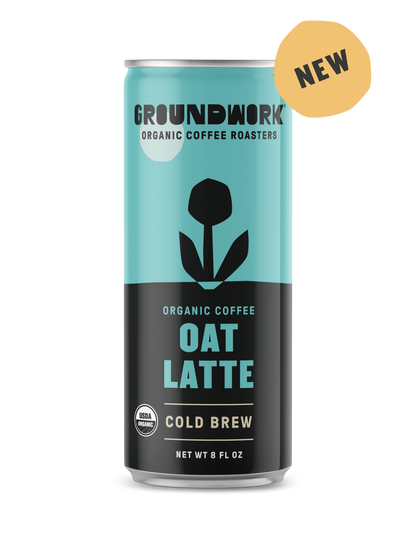 A can of Groundwork Coffee Organic Cold Brew Latte with a blue and black design, flower graphic, and yellow "NEW" label on the top right.