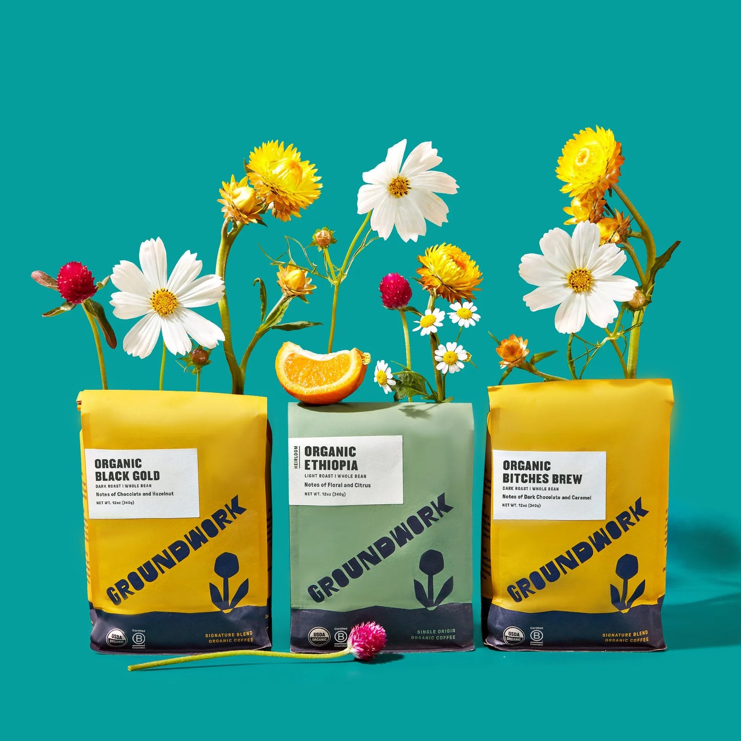 Three colorful Groundwork Coffee bags, including the Best-Sellers Coffee Bundle, with flowers and an orange slice on a bright turquoise background.