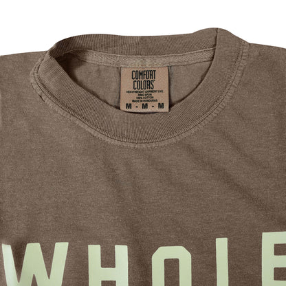 Close up of brown t-shirt crew neckline showing ribbed collar and Comfort Colors interior label